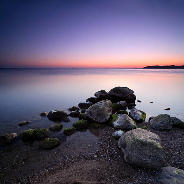 istock Water's Edge with Moss Covered Rocks and Sea 108219375
