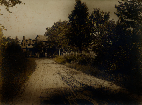 Old photograph of a farmhouse. Age and grunge, printed on fiber paper.