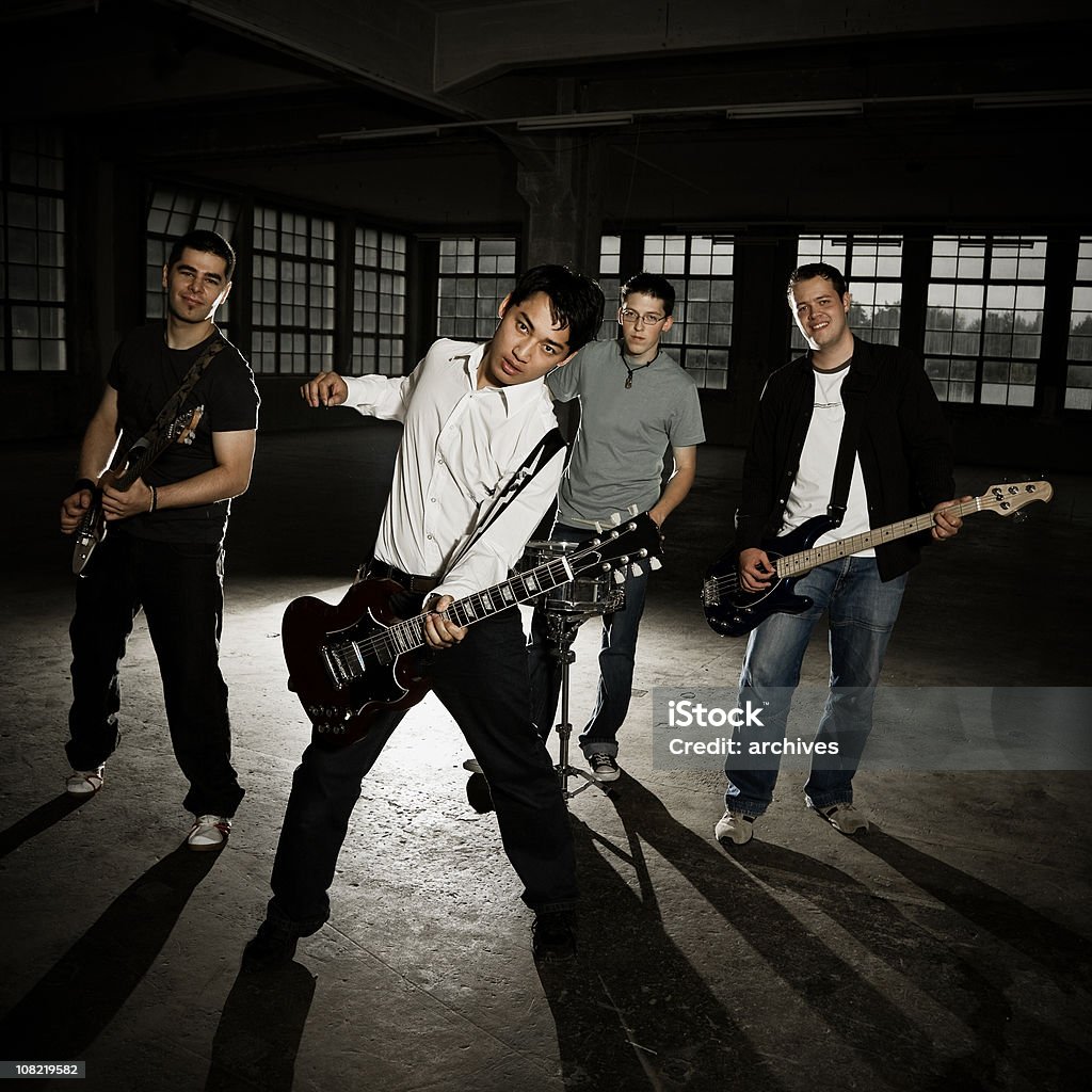 Männer in Band spielt Gitarre auf leere Factory, Low-Key - Lizenzfrei Boygroup Stock-Foto
