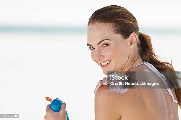 Foto de Bela Jovem Mulher Aplicando Loção Sobre As Costas e mais fotos de stock de Protetor Solar - Protetor Solar, Mulheres, Praia