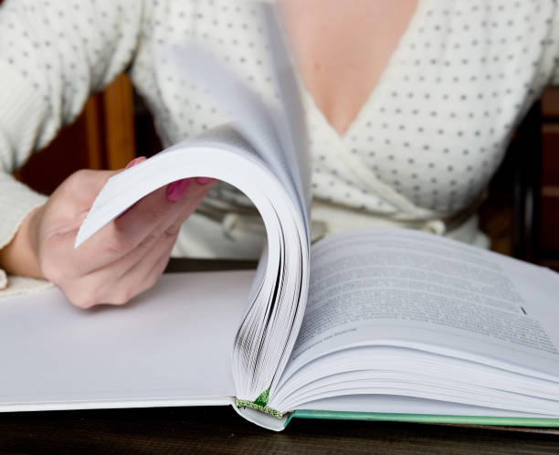 istock Turns the pages of the book 1082197144