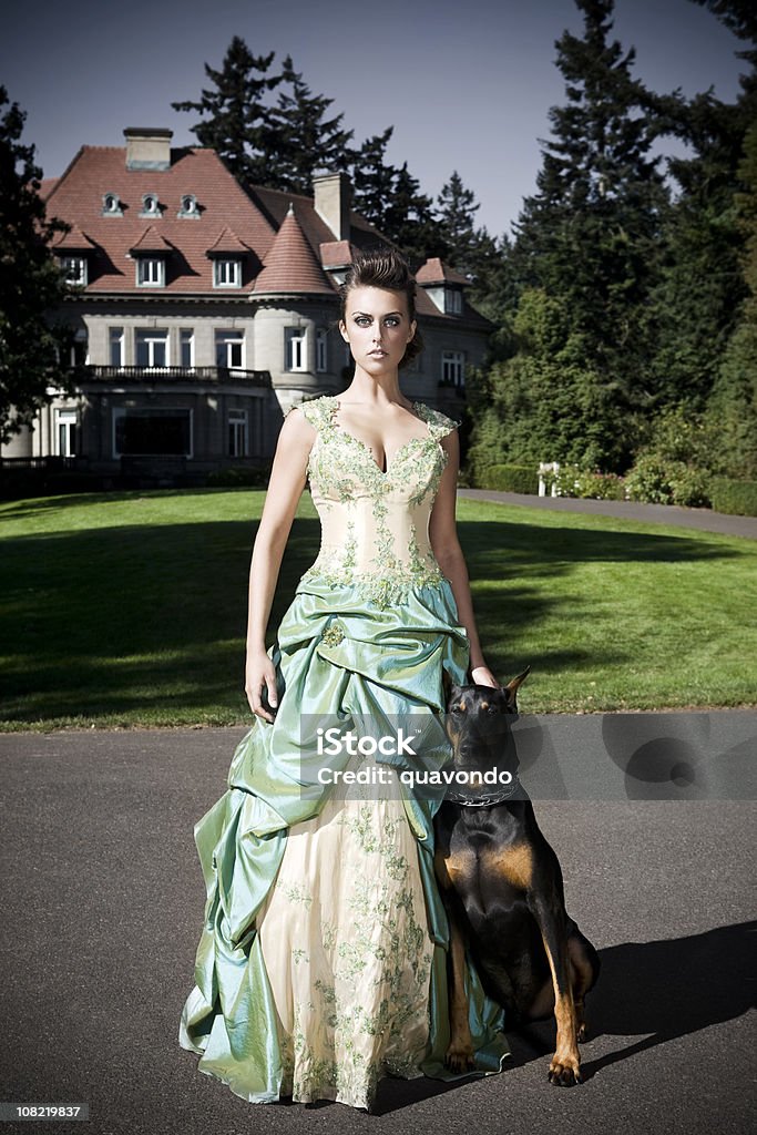 Belle Princesse en robe de soirée avec un Doberman extérieur du château - Photo de Demeure libre de droits