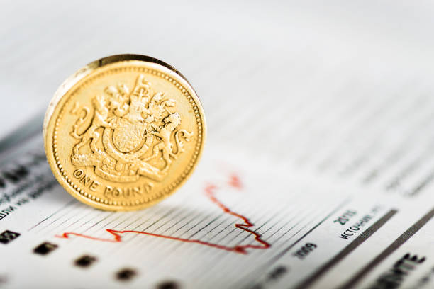 One pound coin on fluctuating graph. Rate of the pound sterling (shallow DOF) stock photo