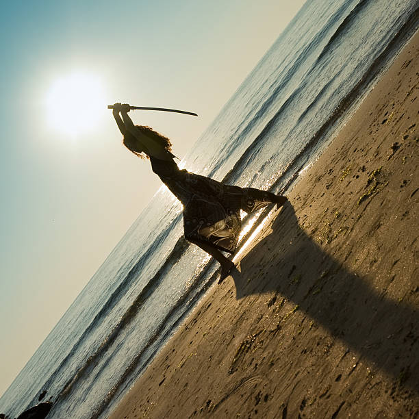 Asian Young woman enjoying freedom at the beach. Beautiful female model under sunset at seaside. Calm water reflects woman silhouette. Sun goes behind horizon. Girl is alone.