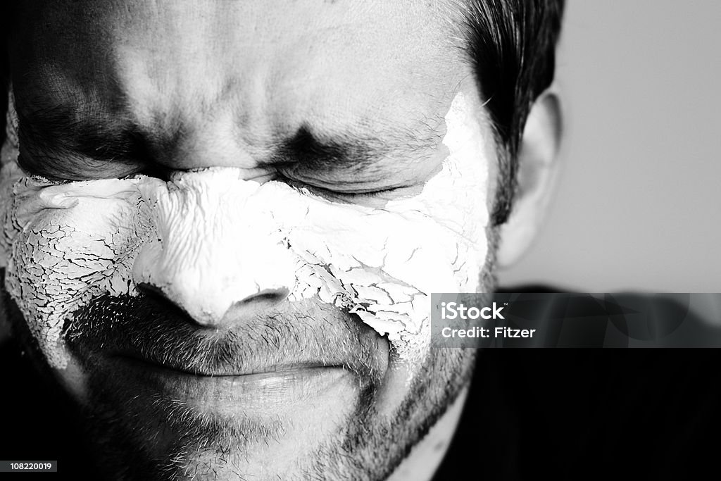 Hombre usando máscara Facial de arcilla y Wincing - Foto de stock de 30-39 años libre de derechos