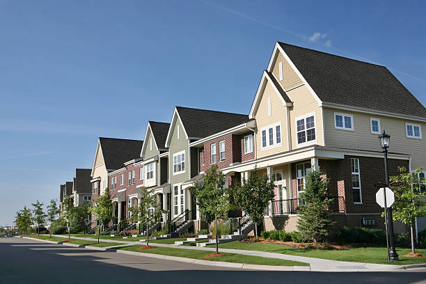 Row of Suburban Townhouses on Summer Day Perfectly manicured row of suburban townhouses on a beautiful summer day. townhouse stock pictures, royalty-free photos & images