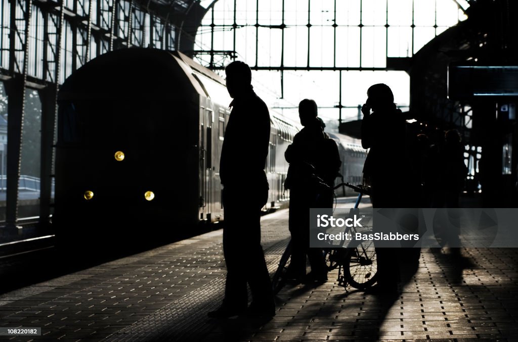 Ferrovie, Silhouette di persone in piedi sulla piattaforma nel treno arriva - Foto stock royalty-free di Ambientazione interna