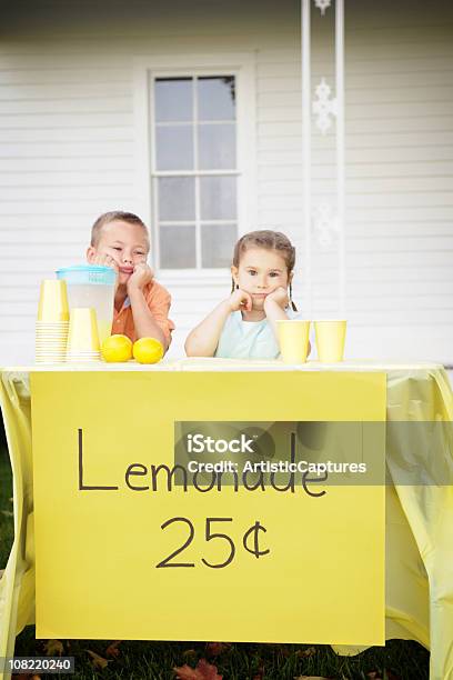 Aburrido Little Boy And Girl Sesión En Tenderete De Refrescos Foto de stock y más banco de imágenes de Tenderete de refrescos