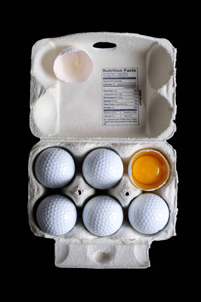 istock Golf Balls in Egg Carton with Broken One Showing Yolk 108220357