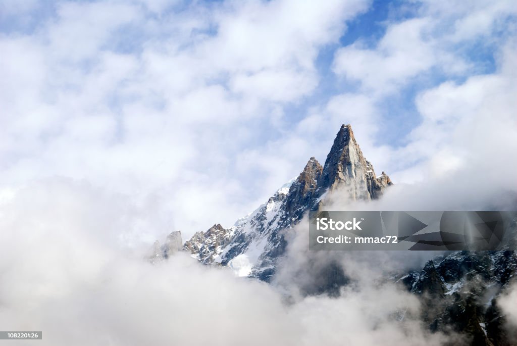 El pico de la montaña rodeado por nubes - Foto de stock de Acantilado libre de derechos