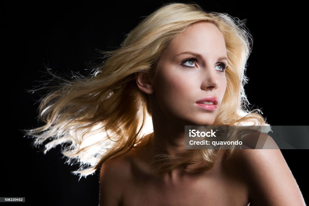 Piękna Blond Młoda kobieta na czarno Patrząc w górę, Potargane włosy - Zbiór zdjęć royalty-free (Blond włosy)
