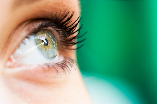 Drops from vial dripping into woman eye closeup. Conjunctivitis treatment concept