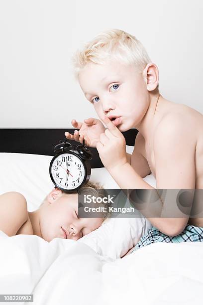 Rapaz Mantém Despertador Para Dormir Irmão - Fotografias de stock e mais imagens de 6-7 Anos - 6-7 Anos, Acordar, Branco