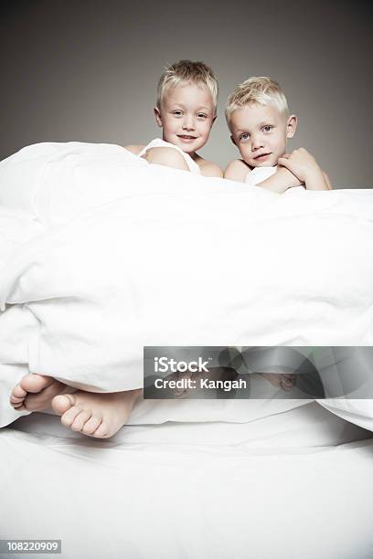 Dos Hermanos Rubia Sentada En La Cama Foto de stock y más banco de imágenes de 6-7 años - 6-7 años, Blanco - Color, Cama