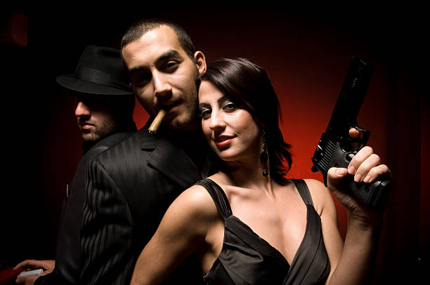 istock Woman Holding Gun Posing with Two Men in Suits 108221009