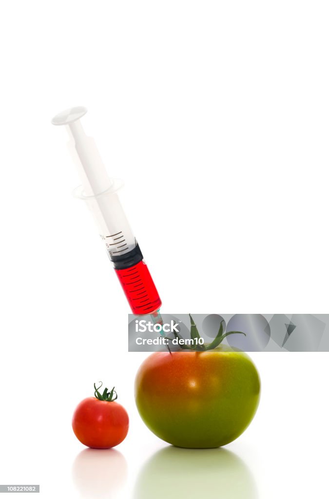 Spritze Spritzen Rote Flüssigkeit in eine Grüne Tomate - Lizenzfrei Farbbild Stock-Foto
