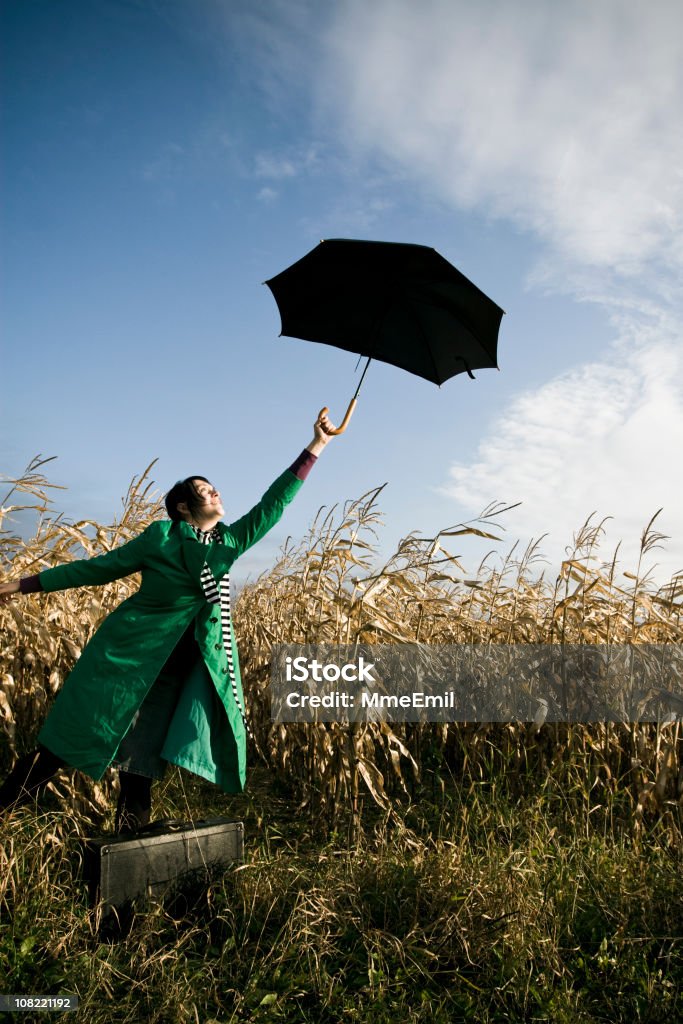 Jovem mulher segurando Guarda-chuva e de pé num campo de Milho - Royalty-free Azul Foto de stock