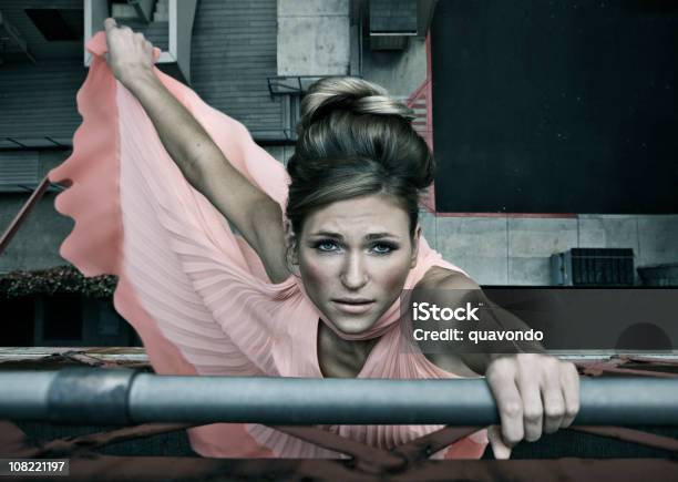 Beautiful Young Woman Fashion Model In Dress Hanging Off Bridge Stock Photo - Download Image Now