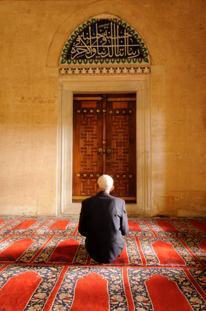 A Muslim man praying in a mosque stock photo