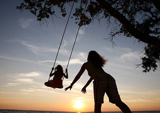 Child enjoying swinging in sunset light