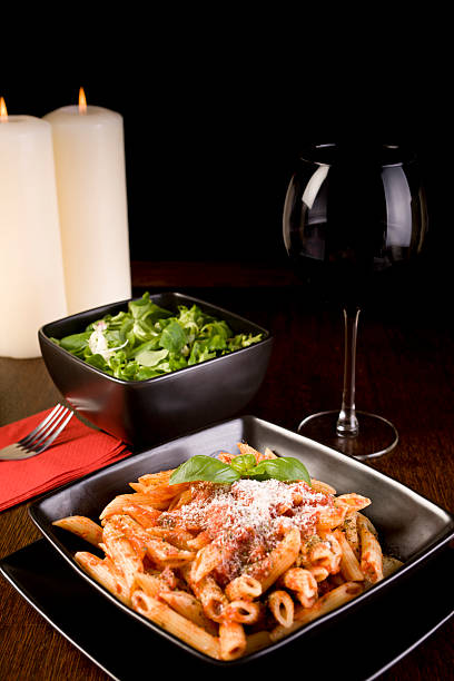 Penne Pasta Bolognese Dinner with Salad, Red Wine and Candles