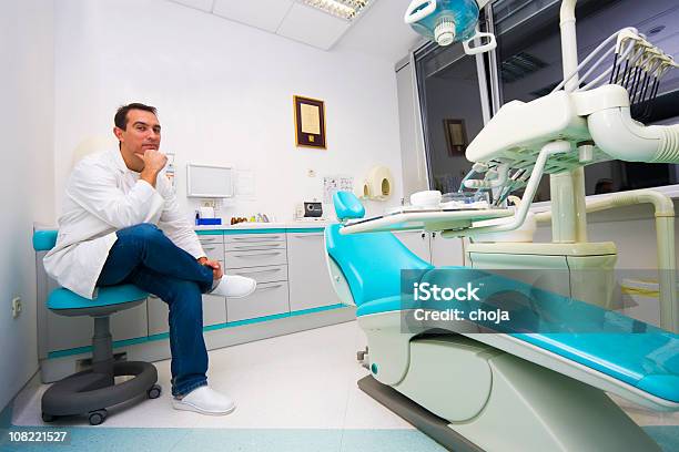 Młody Dentysta W Biurze - zdjęcia stockowe i więcej obrazów Dentysta - Dentysta, Kontemplacja, Cała postać