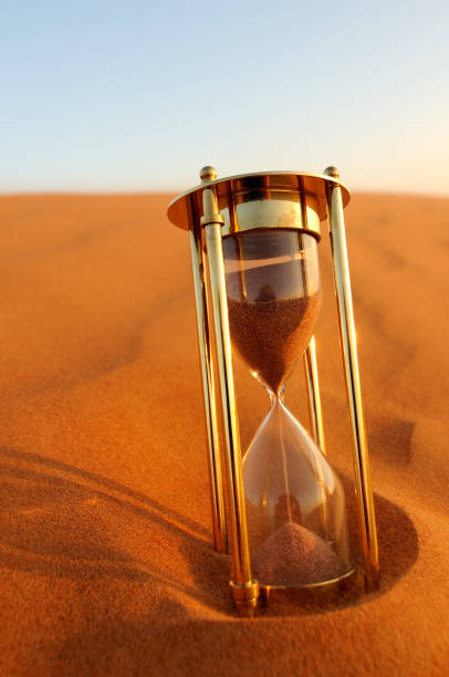 istock Hourglass Sitting in Desert Sand at Dusk 108221726
