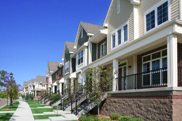 Row of Townhouses on Suburban Street Row of perfectly manicured suburban townhouses on a beautiful summer day. townhouse stock pictures, royalty-free photos & images