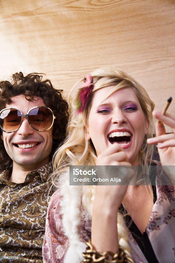 Giovane donna ridere con Hippy uomo che fuma Marijuana - Foto stock royalty-free di Party