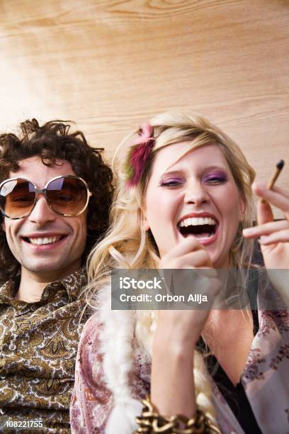 Giovane Donna Ridere Con Hippy Uomo Che Fuma Marijuana - Fotografie stock e altre immagini di Party