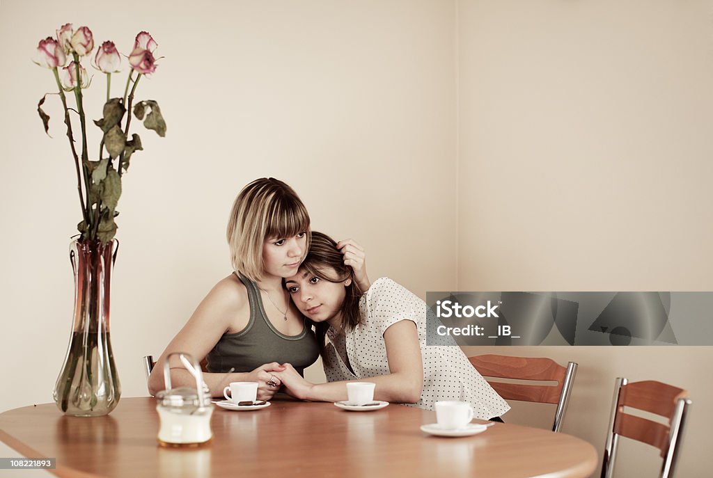 Две молодых женщины держат друг друга в ресторане Kitchen Table - Стоковые фото Близость роялти-фри