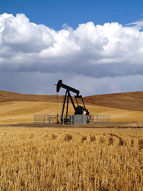 Preto Poço de Petróleo Pumpjack com a tempestade s'aproximando - foto de acervo