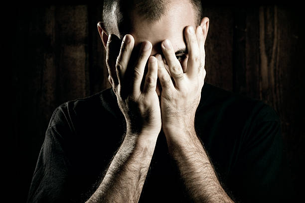 istock Young Man Holding His Face in Hands, Low Key Lit 108222085