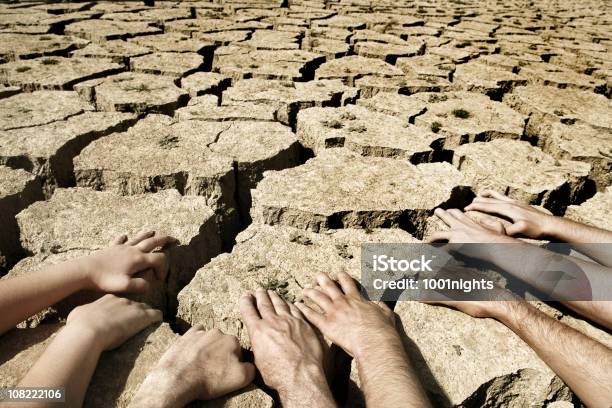 Homem E Mulher Mãos Assentes No Deserto Solos Áridos - Fotografias de stock e mais imagens de Deserto