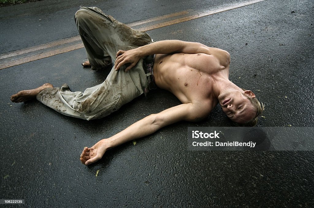 상반신 노출 젊은 남자 라잉 in Middle of 습함 Road - 로열티 프리 죽은 사람 스톡 사진