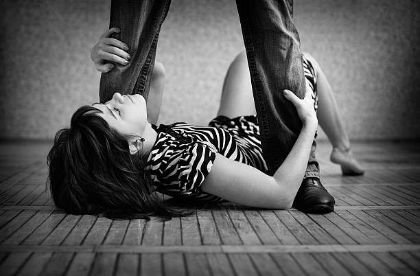 homme debout sur une jeune femme allongée sur le sol - crouching male men sensuality photos et images de collection