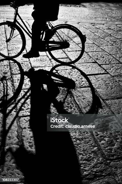 Sagoma Della Persona Bicyling Sulla Strada Di Ciottoli Bianco E Nero - Fotografie stock e altre immagini di Acciottolato