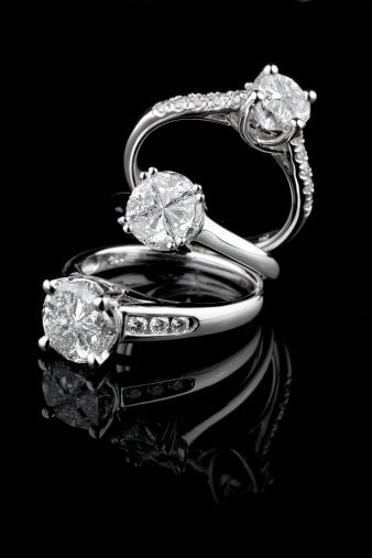 Tres diamantes blanco anillos de oro sobre fondo negro photo