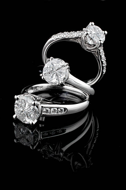 trois anneaux de diamant or blanc sur fond noir - ring jewelry diamond luxury photos et images de collection