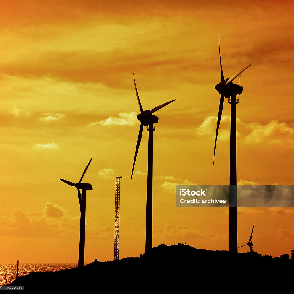 Silhuetas de turbinas de vento na Colina ao pôr do sol - Royalty-free Amarelo Foto de stock