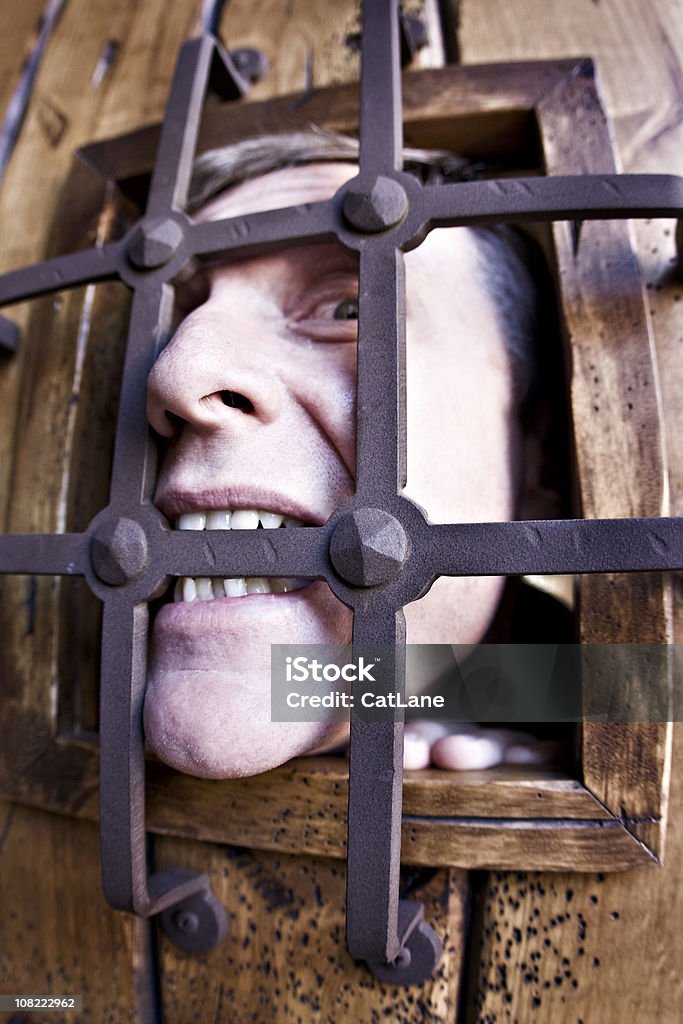Homem mordendo bares de prisão - Foto de stock de Esquisito royalty-free