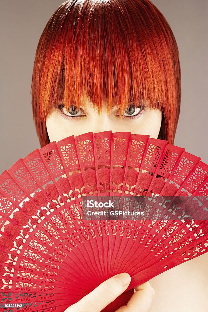 Młoda kobieta Trzymając czerwony japoński składany przed twarz - Zbiór zdjęć royalty-free (20-24 lata)