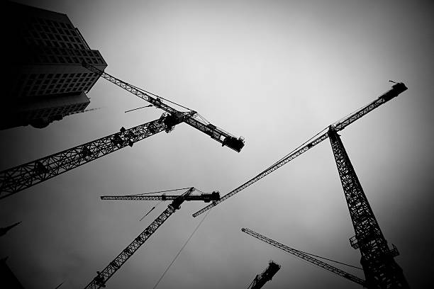 High rise Construction B/W Processed scene with high rise cranes in a construction site in Berlin construction skyscraper machine industry stock pictures, royalty-free photos & images