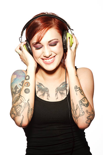 sorridente jovem mulher com tatuagens ouvir auscultadores - funky people cool women imagens e fotografias de stock