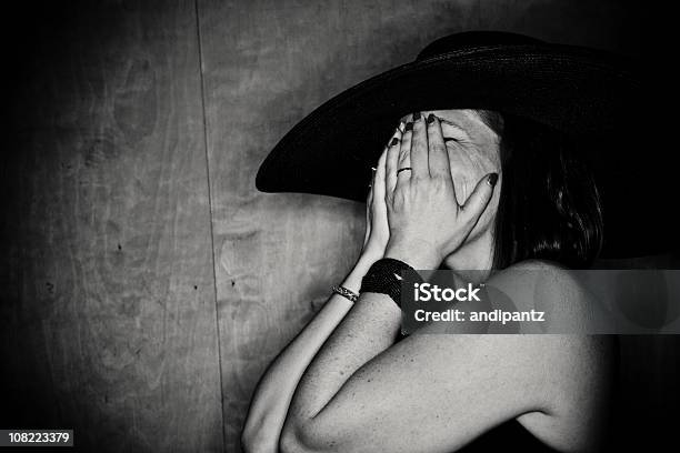Woman Covering Face With Hands Wearing Hat Black And White Stock Photo - Download Image Now