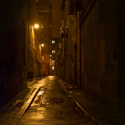 Dark urban alleyways. The light of a street lamp.