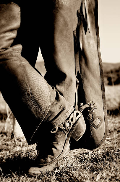Man's Cowboy Boots and Leather Chaps, Sepia Toned stock photo