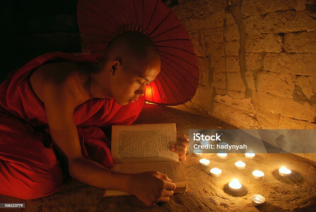 Young monk reading a book  Candle Stock Photo