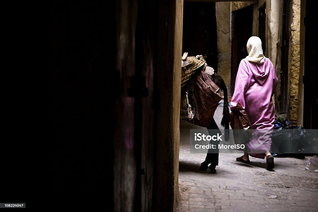 Arabska kobieta chodzić w wąskiej uliczce - Zbiór zdjęć royalty-free (Marrakesz)