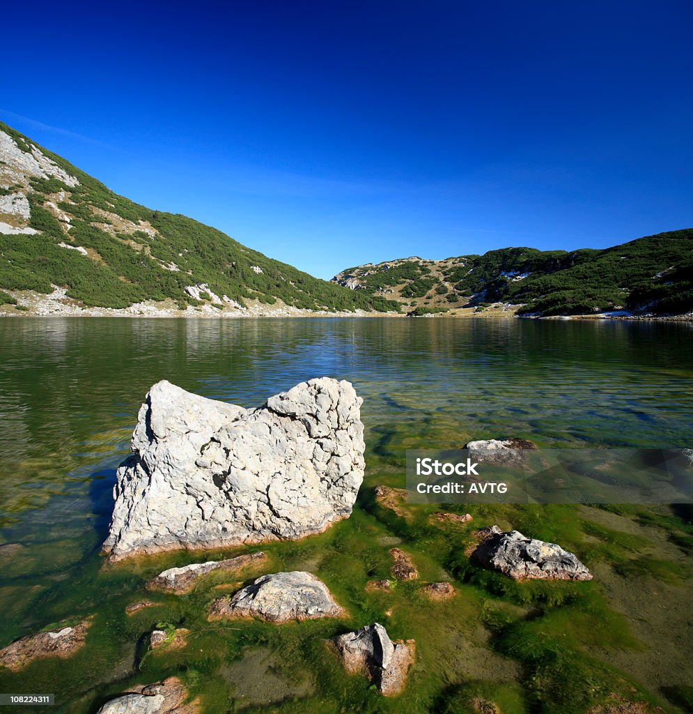 Lago de montaña con Moss rocas cubiertas y cielo azul - Foto de stock de Aire libre libre de derechos